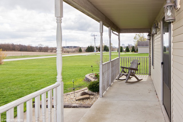 3325 East 19th Road Ottawa, IL 61350 - Photo 16 of 20 a view of a deck with a table chairs and a floor to ceiling window