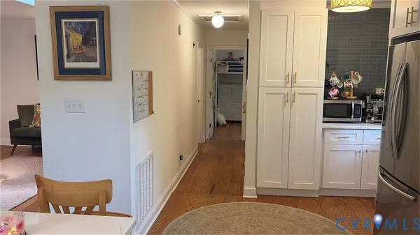 a room with wooden floor pool table and windows