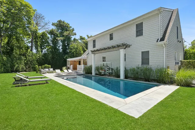 a view of a house with backyard sitting area and garden