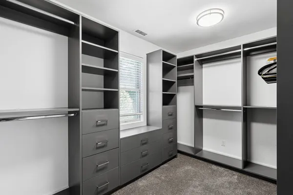 a bedroom with a bed and large windows