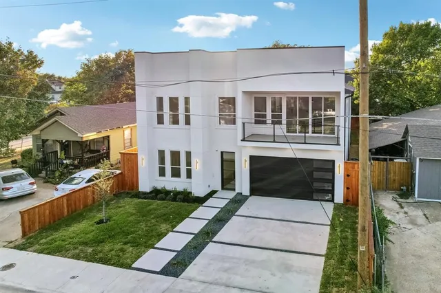 a front view of a house with a yard and potted plants