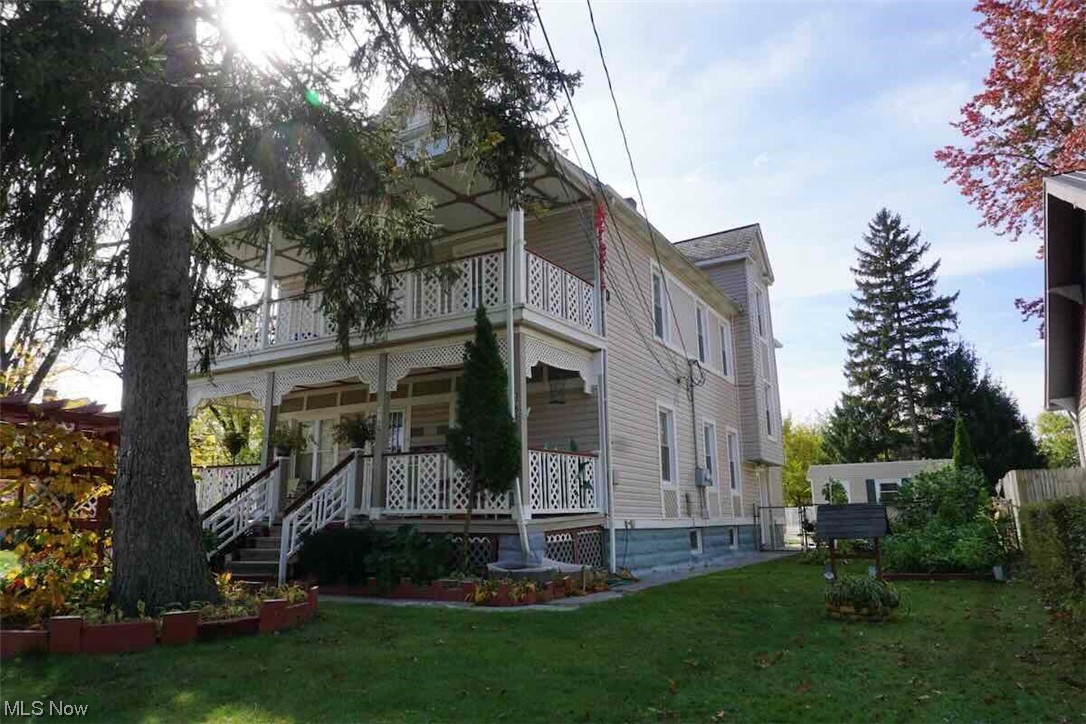 3756 Bosworth Road Cleveland, OH 44111 - Photo 2 of 23 View of side of home featuring a lawn and a balcony