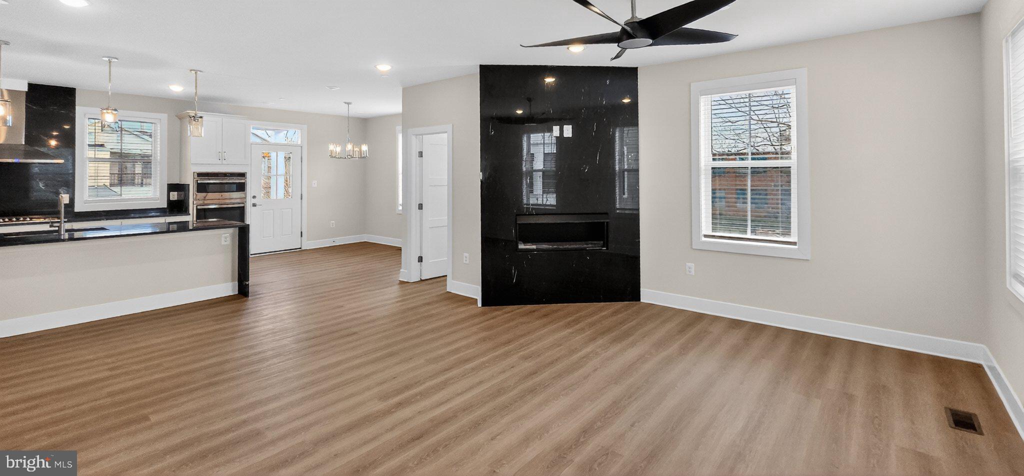 426 Chapel Alley, Unit 8 Frederick, MD 21701 - Photo 18 of 34 an empty room with wooden floor kitchen view and windows