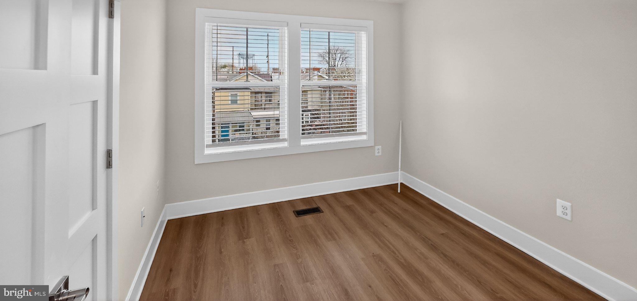 426 Chapel Alley, Unit 8 Frederick, MD 21701 - Photo 29 of 34 a view of an empty room with wooden floor and a window