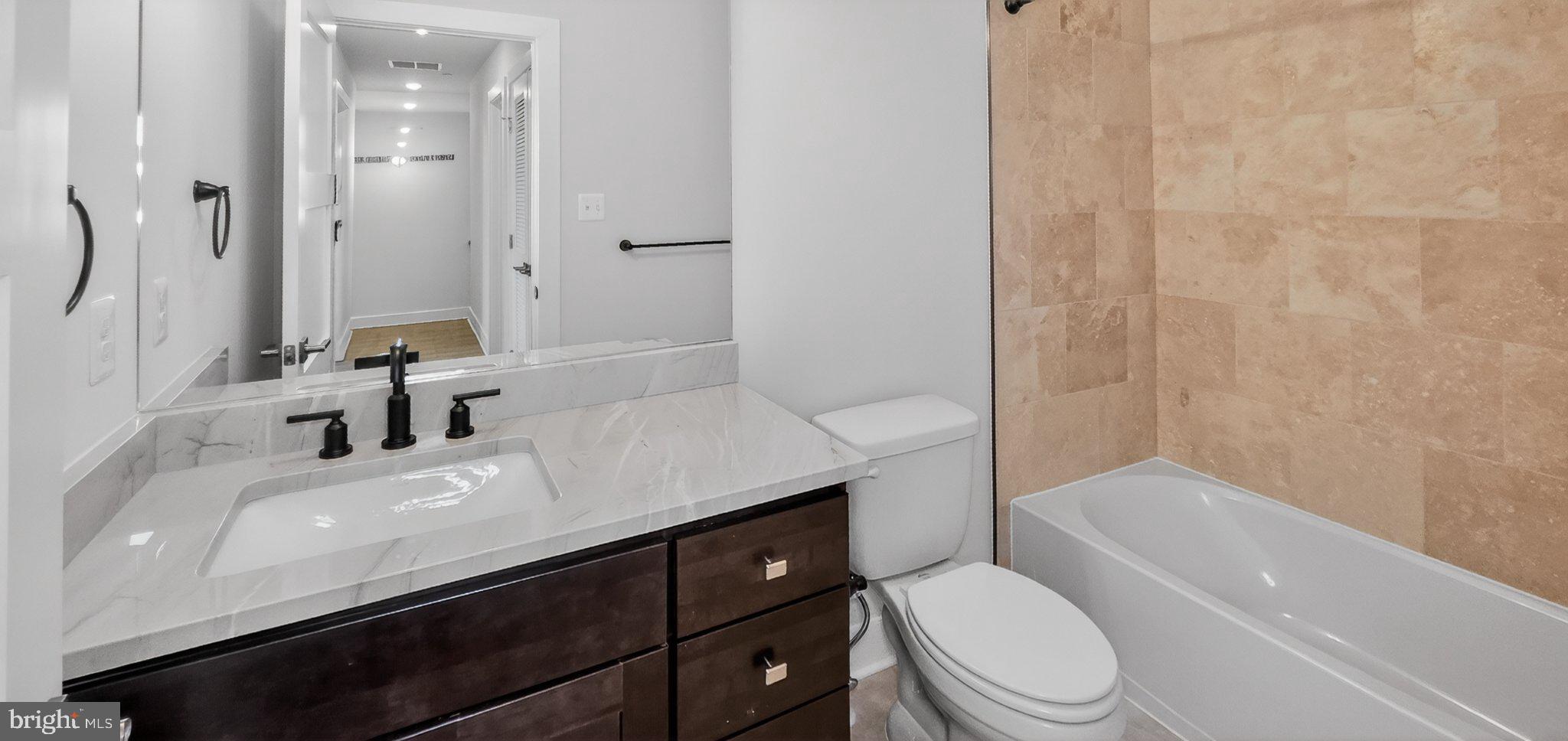 426 Chapel Alley, Unit 8 Frederick, MD 21701 - Photo 31 of 34 a bathroom with a sink a toilet and shower