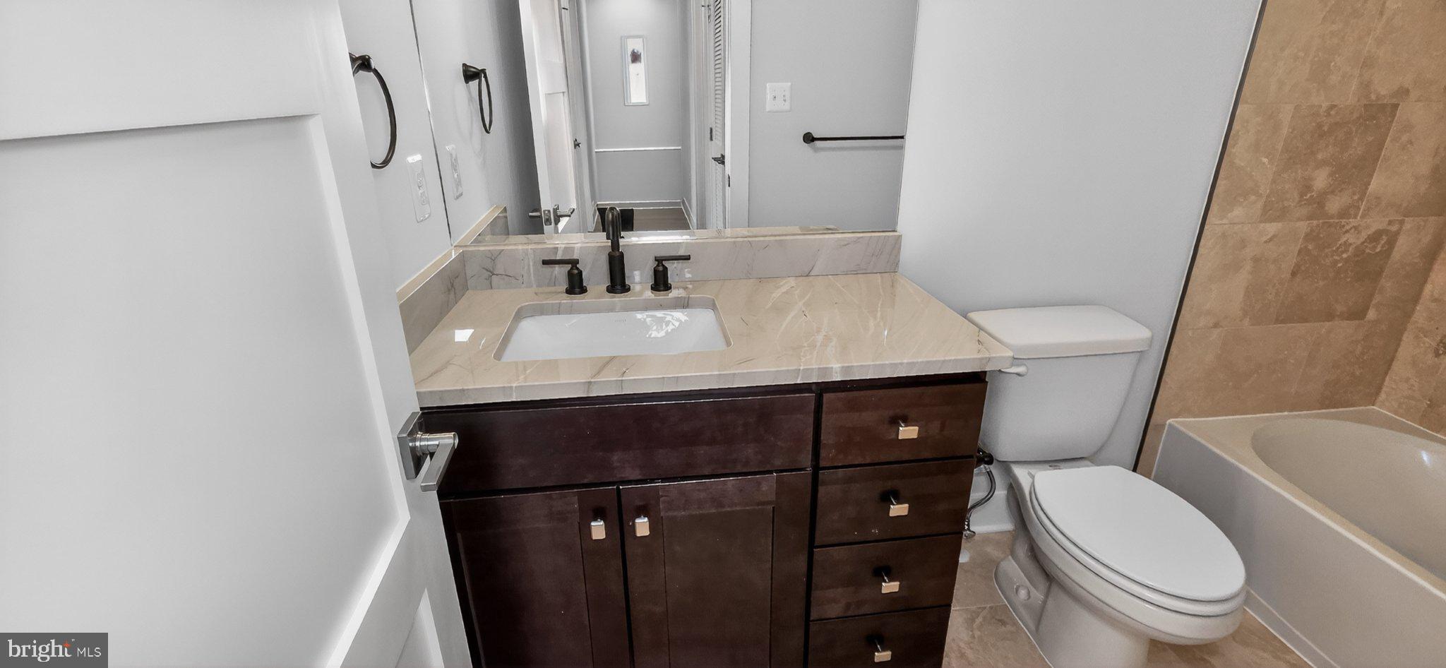 426 Chapel Alley, Unit 8 Frederick, MD 21701 - Photo 32 of 34 a bathroom with a sink a toilet a mirror and vanity