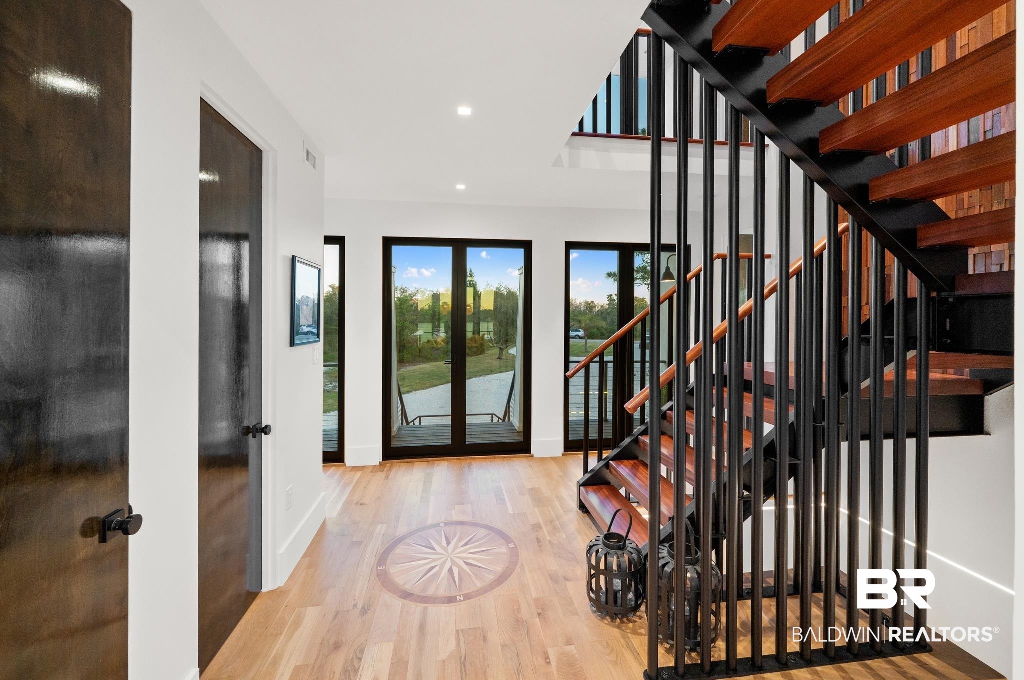 33349 River Road Orange Beach, AL 36561 - Photo 14 of 61 Modern open-tread staircase with wood-finish steps and black metal railings