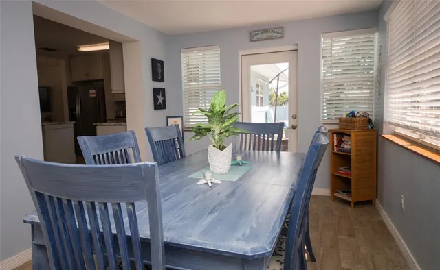 a dining room with furniture potted plants and wooden floor
