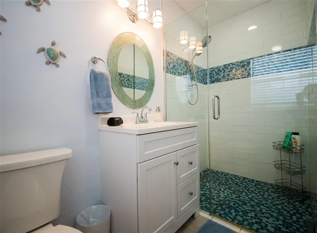 a bathroom with a sink a mirror a toilet and a shower