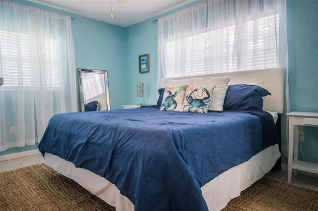 a large bed sitting in a bedroom next to a window