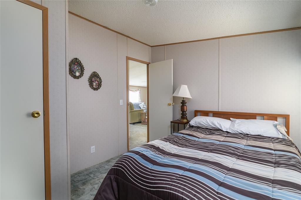 122 Grice Road Ringgold, LA 71068 - Photo 18 of 26 Bedroom with paneled walls, textured ceiling, and wood-finish trim