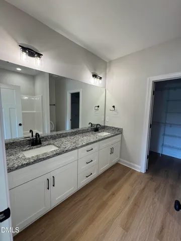 a spacious bathroom with double sink and a large mirror