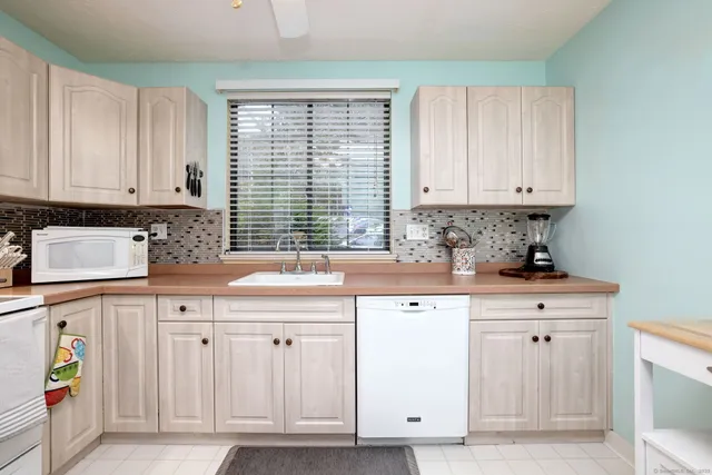 a kitchen with white cabinets and sink