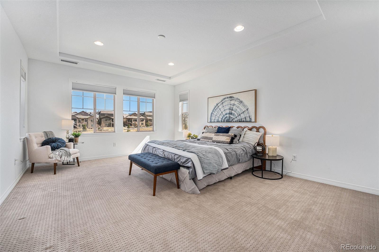 10610 Greycliffe Drive Highlands Ranch, CO 80126 - Photo 25 of 49 a spacious bedroom with a bed a table and chair