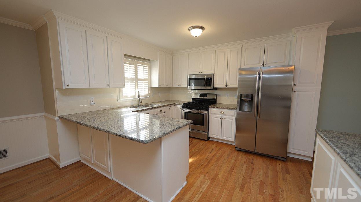 4115 Rockingham Drive Raleigh, NC 27609 - Photo 3 of 23 a kitchen with granite countertop a refrigerator stove and sink