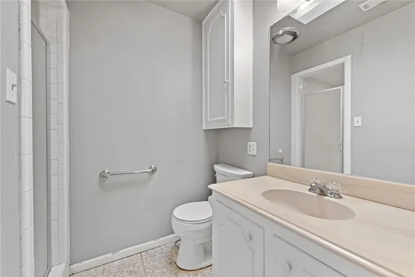 a bathroom with a granite countertop toilet and sink