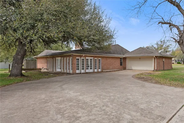 a view of a house with a yard and large tree