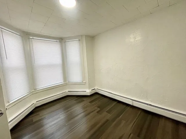 a view of room with window and wooden floor