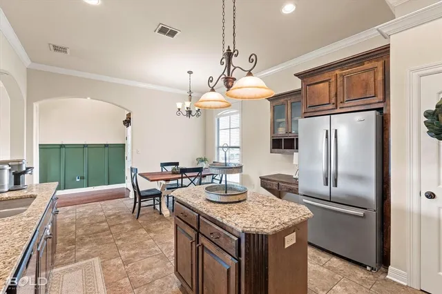 a kitchen with a table chairs refrigerator and cabinets