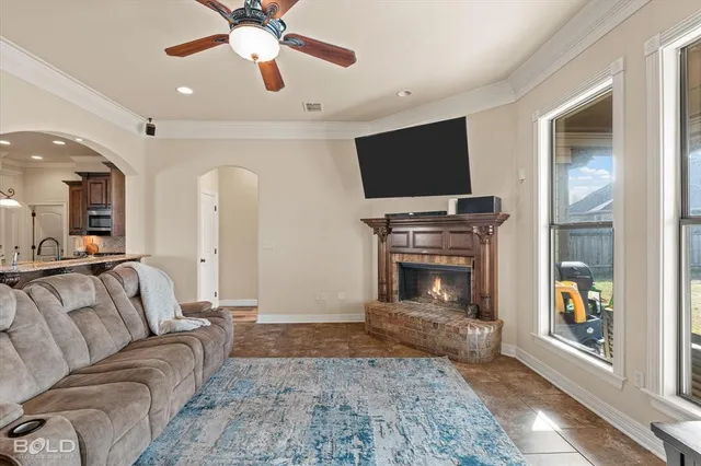 a living room with furniture a flat screen tv and a fireplace