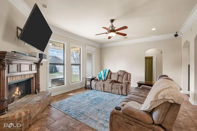 a living room with furniture a fireplace and a flat screen tv