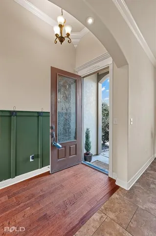 en empty room with stairs and a chandelier fan