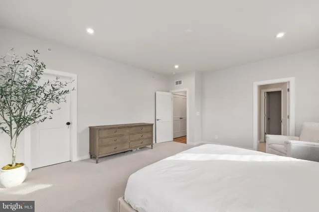 a bedroom with a bed and a potted plant