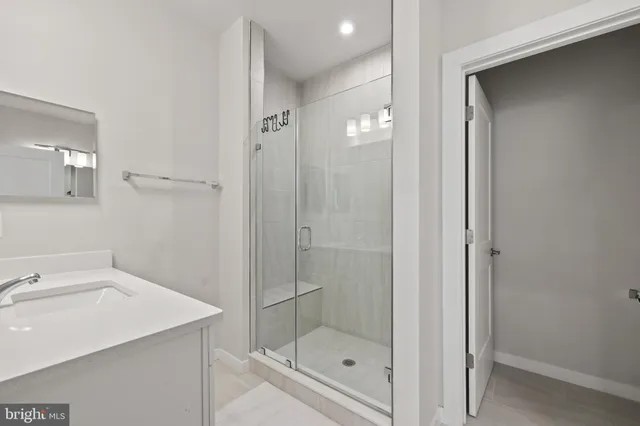 a bathroom with a shower sink and mirror