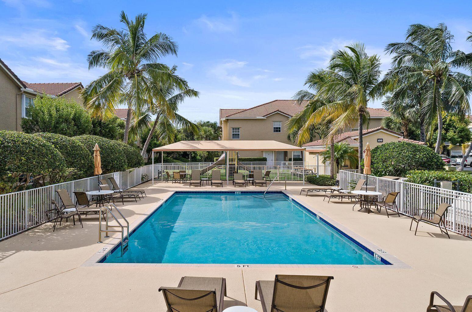 105 Lighthouse Circle, Unit J Tequesta, FL 33469 - Photo 16 of 18 a swimming pool with outdoor seating and yard
