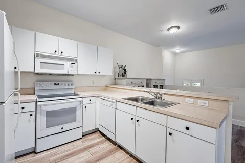 a kitchen with white cabinets stainless steel appliances and sink