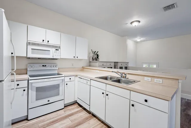 a kitchen with white cabinets stainless steel appliances and sink