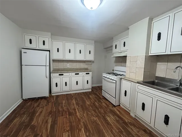 a kitchen with white cabinets and white appliances