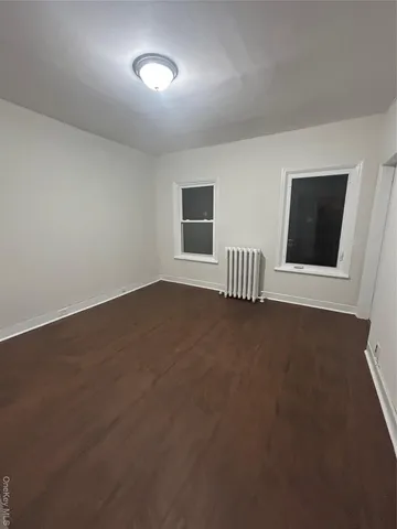 an empty room with a chair and front door