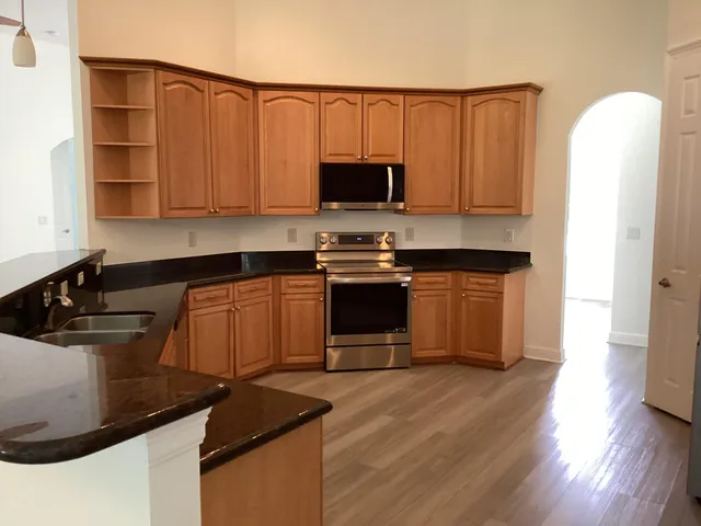 a kitchen with stainless steel appliances a refrigerator microwave and sink
