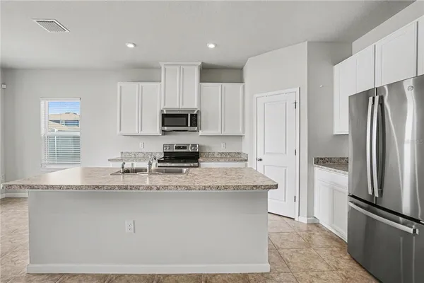 a kitchen with stainless steel appliances granite countertop a refrigerator a stove a sink and a granite counter tops