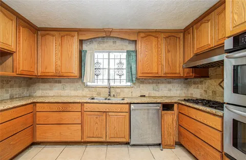 a kitchen with stainless steel appliances granite countertop a sink stove and cabinets