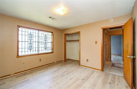 an empty room with wooden floor and a window
