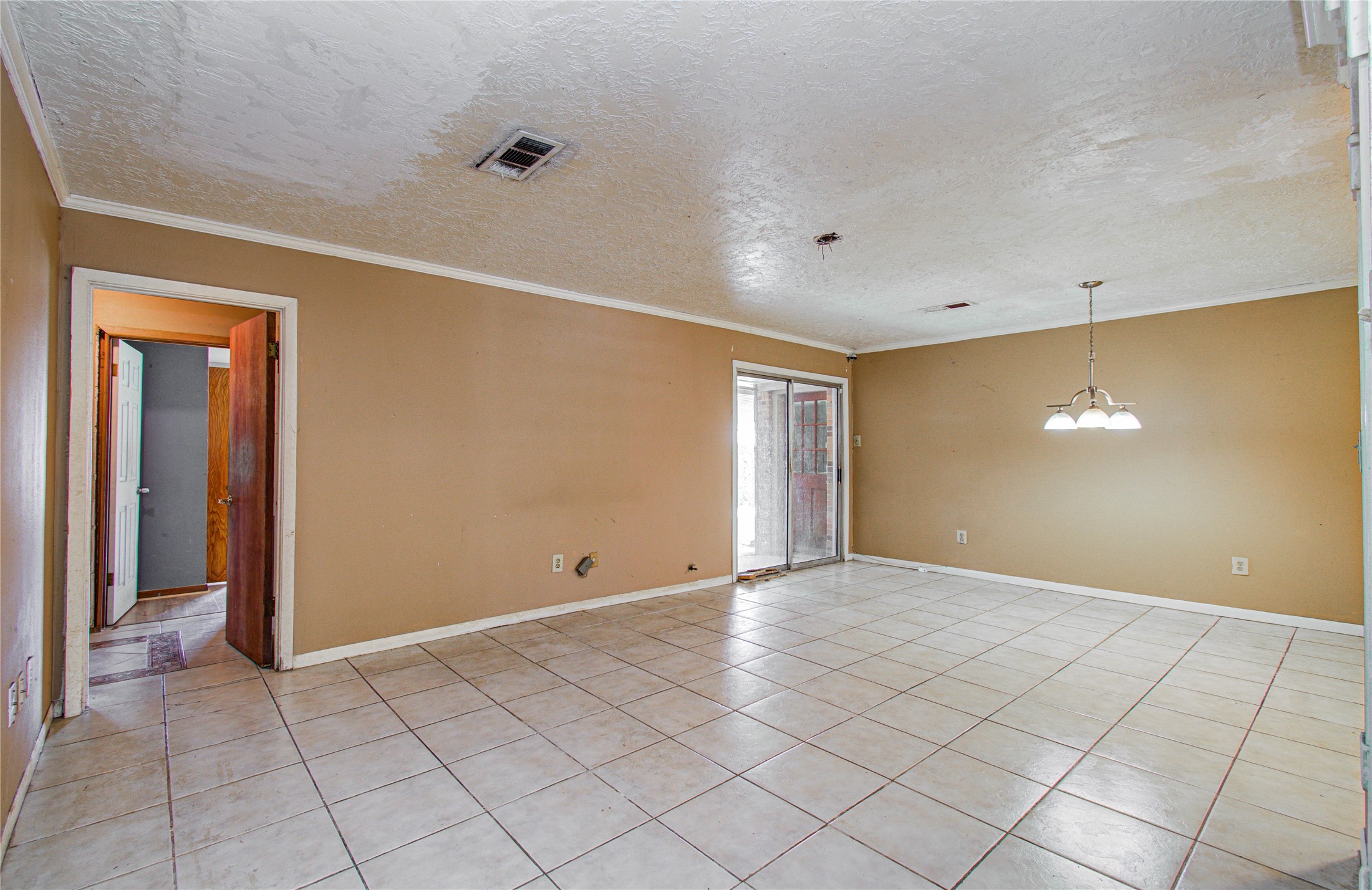 8428 Swiftwater Lane Houston, TX 77075 - Photo 7 of 26 Spacious living room features tiled flooring, neutral walls, and a ceiling light fixture. It includes a sliding glass door leading to an outdoor area, enhancing natural light. Perfect for a dining or living space.