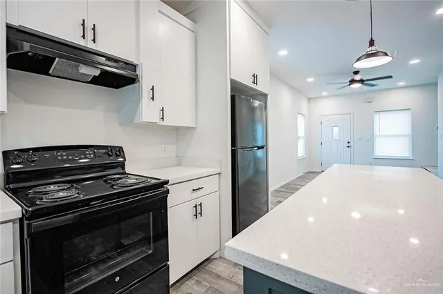 a kitchen with stainless steel appliances a stove a microwave and white cabinets