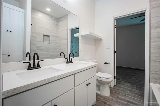 a bathroom with a sink a toilet and a mirror