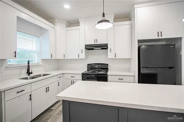 a kitchen with a sink a stove and refrigerator