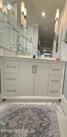 a bathroom with a double vanity sink mirror and shower