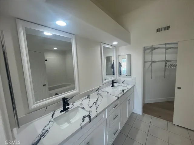 a spacious bathroom with a double vanity sink mirror double and shower