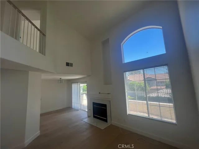 a view of an empty room with a fireplace and a window