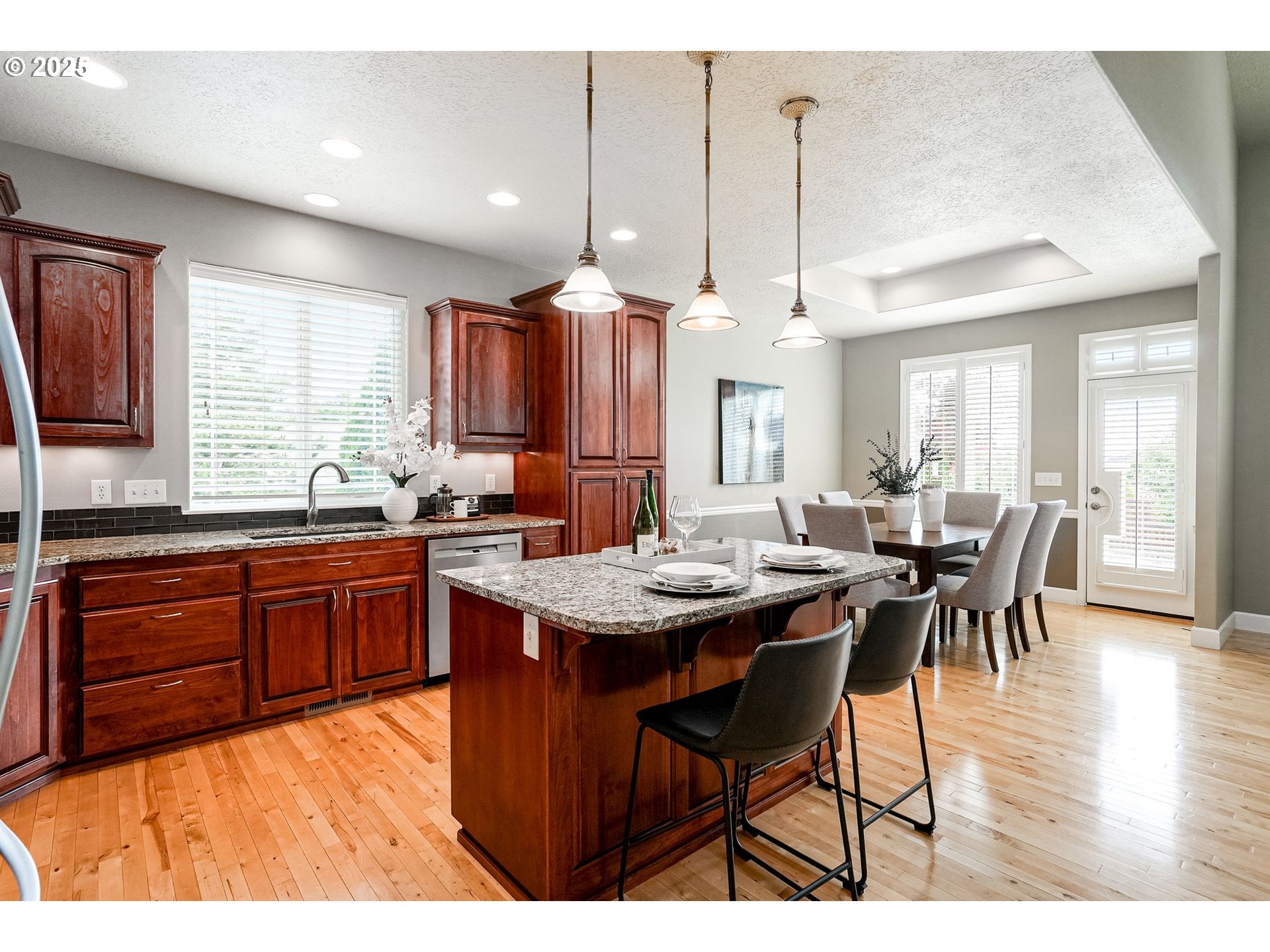413 Northwest Harold Street Sublimity, OR 97385 - Photo 14 of 48 a kitchen with stainless steel appliances granite countertop a stove a sink dishwasher a dining table and chairs with wooden floor