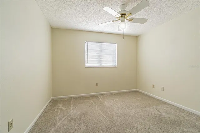 an empty room with closet and a chandelier fan