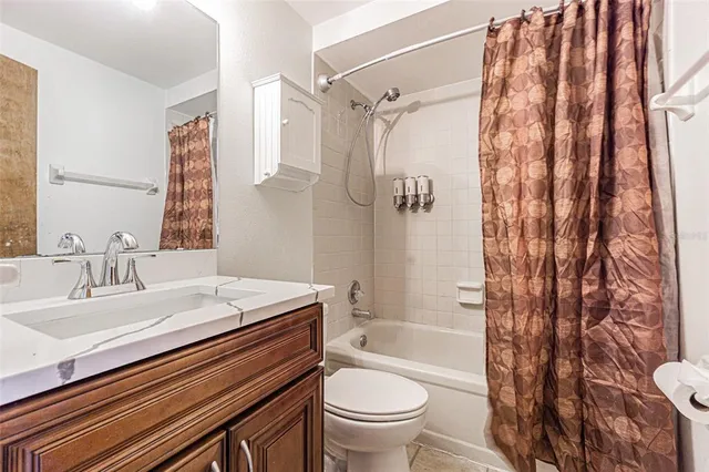 an empty room with a chandelier fan and windows
