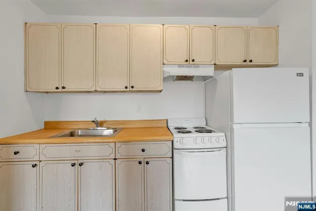 a kitchen with stainless steel appliances white cabinets and a sink