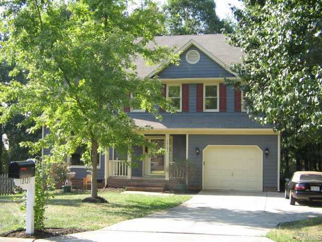 12121 Ranleigh Court Raleigh, NC 27613 - Photo 1 of 8 a front view of a house with a garden and trees