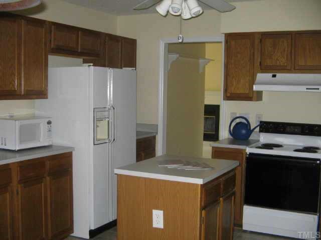 12121 Ranleigh Court Raleigh, NC 27613 - Photo 4 of 8 a kitchen with stainless steel appliances a refrigerator a sink and a stove
